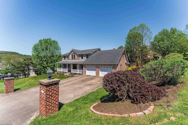 view of front of house with a front lawn, covered porch, brick siding, concrete driveway, and an attached garage