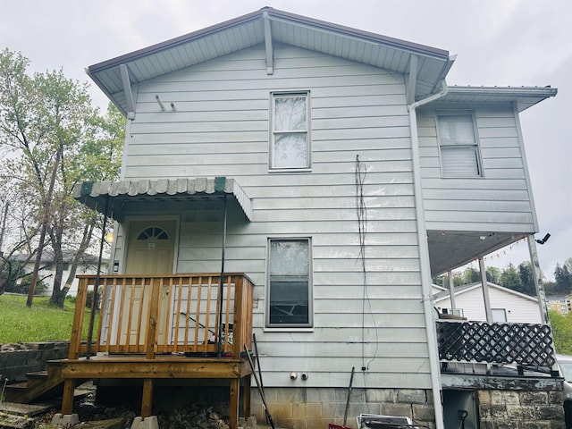 rear view of property featuring a wooden deck