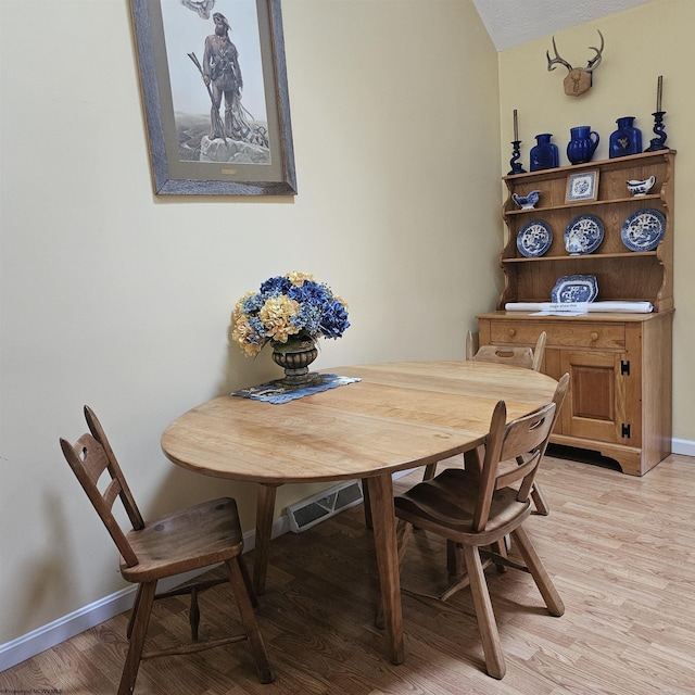 dining space featuring baseboards, visible vents, and light wood-style flooring