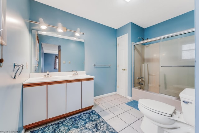 bathroom featuring tile patterned flooring, double vanity, toilet, bath / shower combo with glass door, and a sink