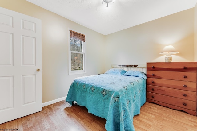 bedroom featuring baseboards and light wood-style floors