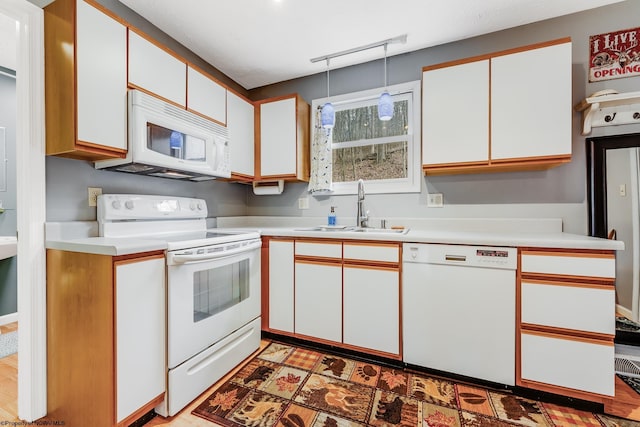 kitchen featuring a sink, white cabinetry, white appliances, and light countertops