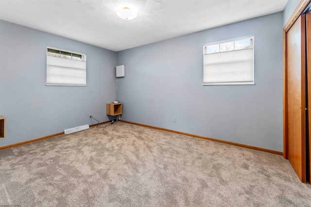 unfurnished bedroom with visible vents, multiple windows, carpet, and a closet