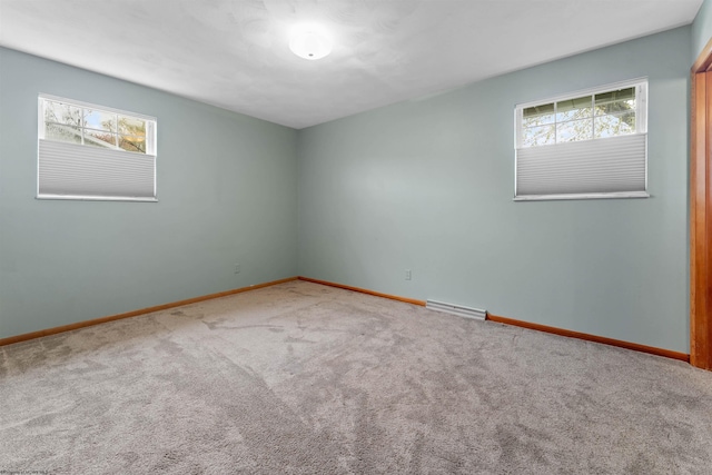 unfurnished room with baseboards, visible vents, a wealth of natural light, and carpet