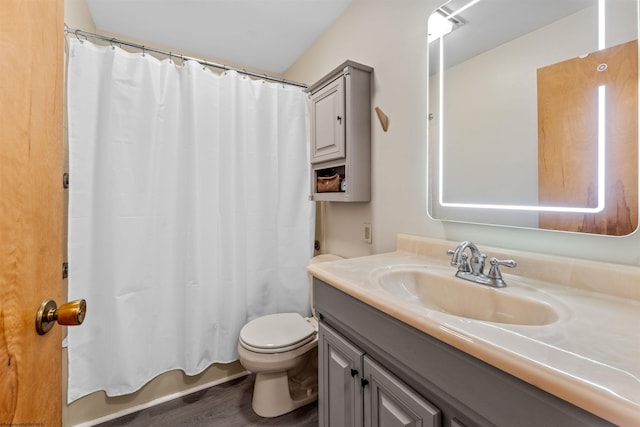full bathroom featuring vanity, toilet, wood finished floors, and shower / tub combo with curtain