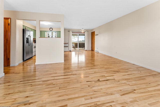 unfurnished living room with baseboards and light wood-style floors