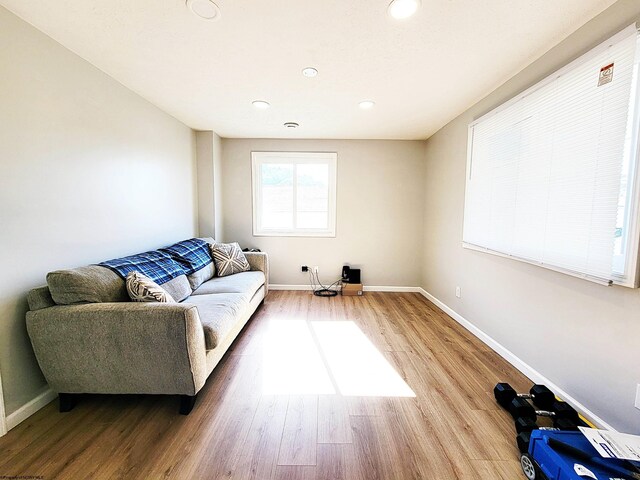 living room featuring baseboards, recessed lighting, and wood finished floors