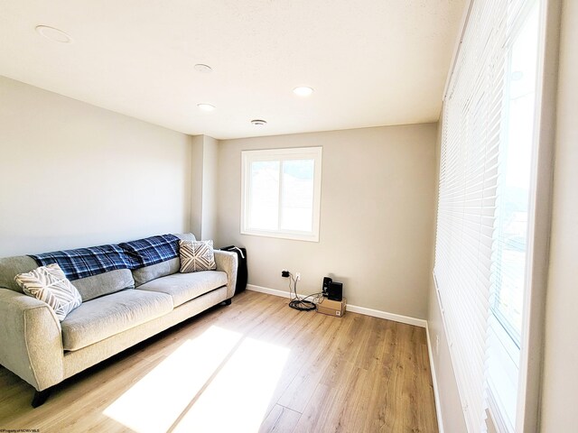 living room with baseboards, recessed lighting, and light wood finished floors
