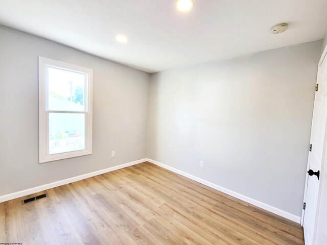 spare room featuring baseboards, visible vents, and light wood-style floors