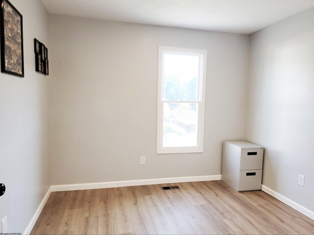 spare room with baseboards, visible vents, a healthy amount of sunlight, and light wood-type flooring