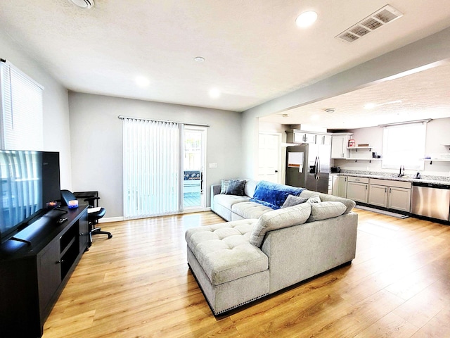 living room featuring visible vents, recessed lighting, and light wood-style flooring