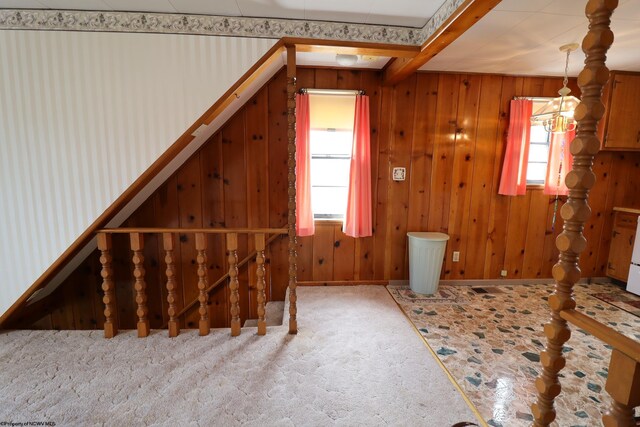 bonus room featuring wooden walls, baseboards, and beam ceiling