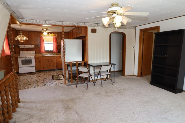 dining area featuring light colored carpet, arched walkways, and ceiling fan