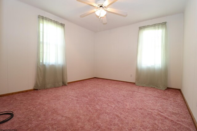 unfurnished room with a ceiling fan, baseboards, and light colored carpet