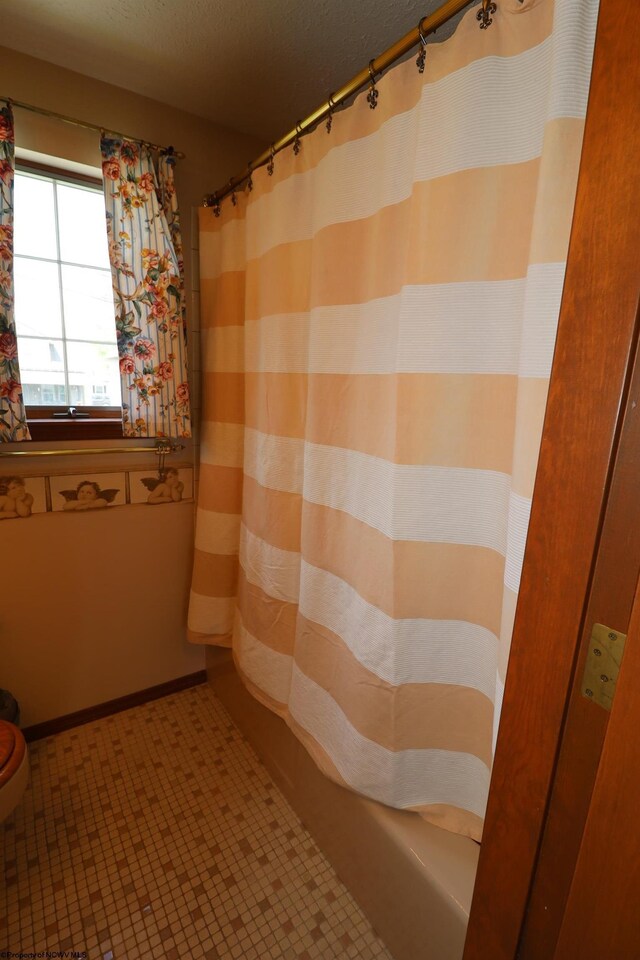 bathroom featuring a shower with curtain and a textured ceiling