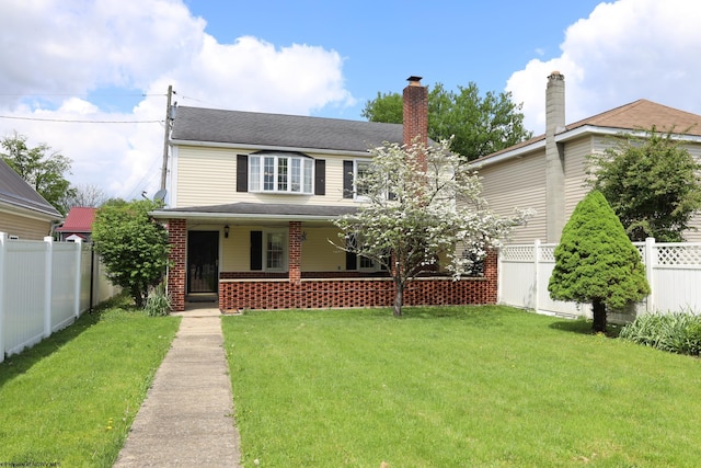 traditional home with covered porch, a chimney, fence private yard, and a front lawn