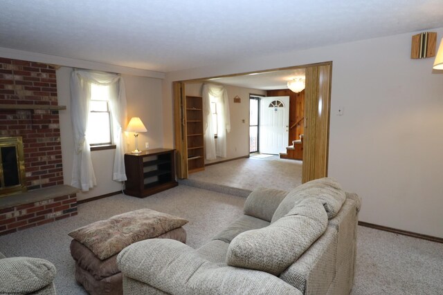 carpeted living area featuring baseboards, stairs, and a fireplace