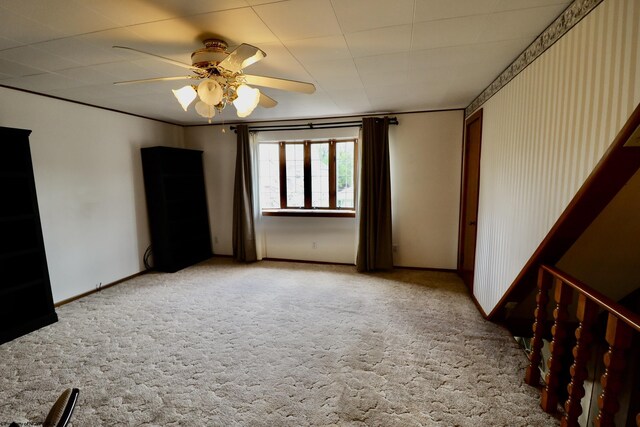 empty room with baseboards, a ceiling fan, and light carpet