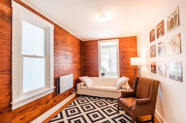 sitting room with wooden walls and wood finished floors