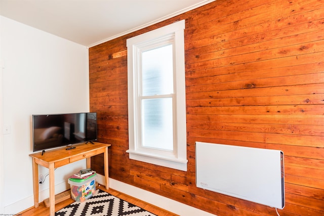 interior space with baseboards, wood walls, and wood finished floors
