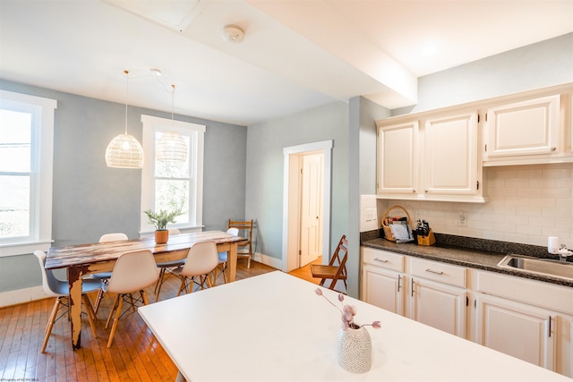 kitchen featuring plenty of natural light, baseboards, backsplash, and hardwood / wood-style floors