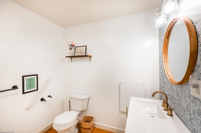 bathroom with toilet, baseboards, and a sink