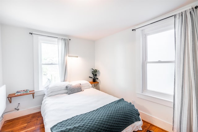 bedroom with baseboards and wood finished floors
