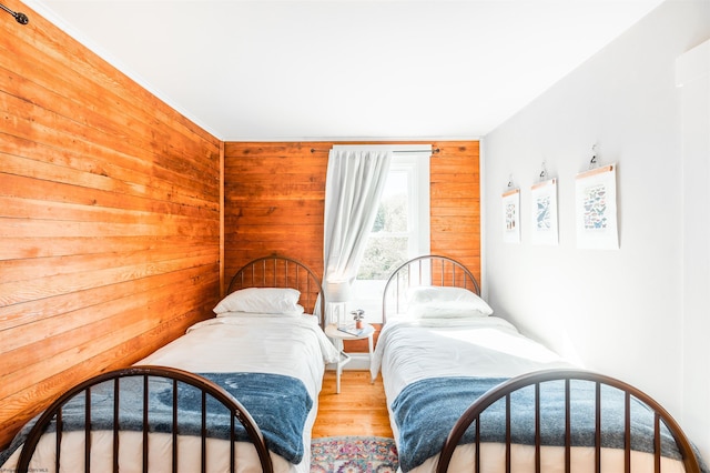 bedroom with wood walls and wood finished floors