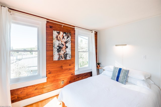 bedroom featuring wooden walls