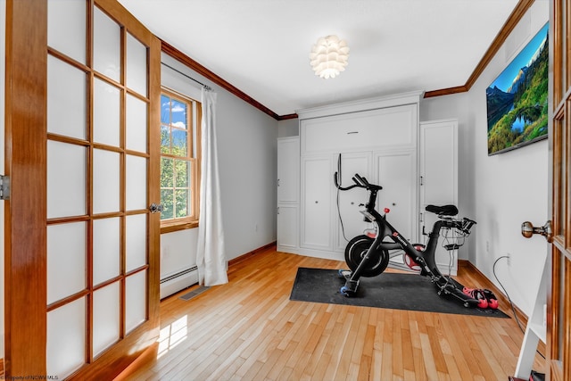 exercise room featuring light wood-style floors, baseboards, and crown molding