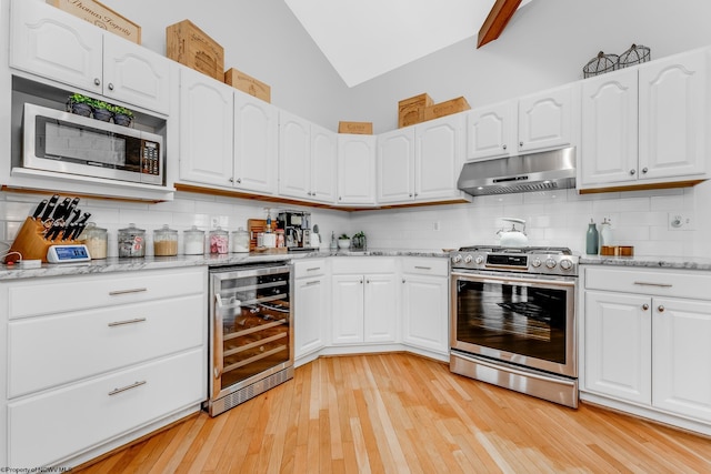 kitchen with beverage cooler, white cabinetry, stainless steel appliances, decorative backsplash, and under cabinet range hood