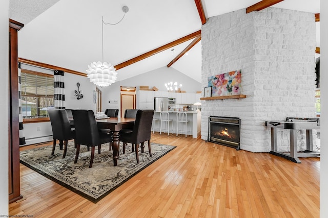 dining area featuring an inviting chandelier, light wood finished floors, a baseboard heating unit, and beam ceiling