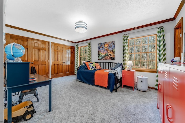carpeted bedroom featuring baseboards, ornamental molding, and a textured ceiling