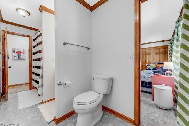 bathroom with crown molding, tile patterned flooring, baseboards, toilet, and connected bathroom