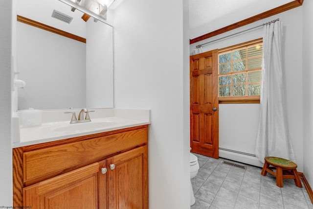 bathroom featuring crown molding, baseboard heating, vanity, toilet, and visible vents