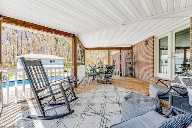 view of patio / terrace featuring a deck, outdoor dining area, and an outdoor pool