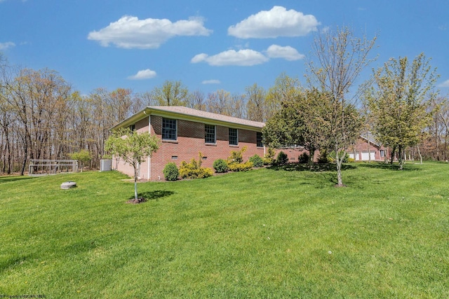 exterior space with brick siding, a garage, and a lawn