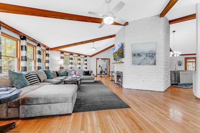 living room featuring vaulted ceiling with beams, a ceiling fan, hardwood / wood-style floors, and a fireplace