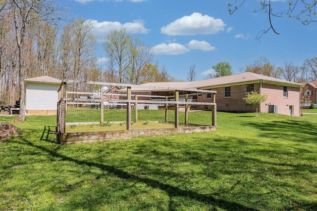 view of yard with central AC and fence