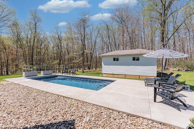 pool with a patio and an outbuilding