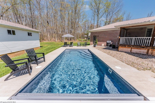 pool with a patio and a lawn