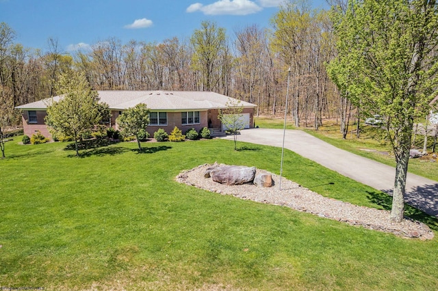 ranch-style house featuring an attached garage, a front lawn, brick siding, and concrete driveway