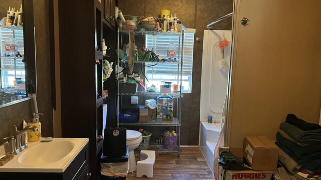 full bath with vanity,  shower combination, wood finished floors, and toilet