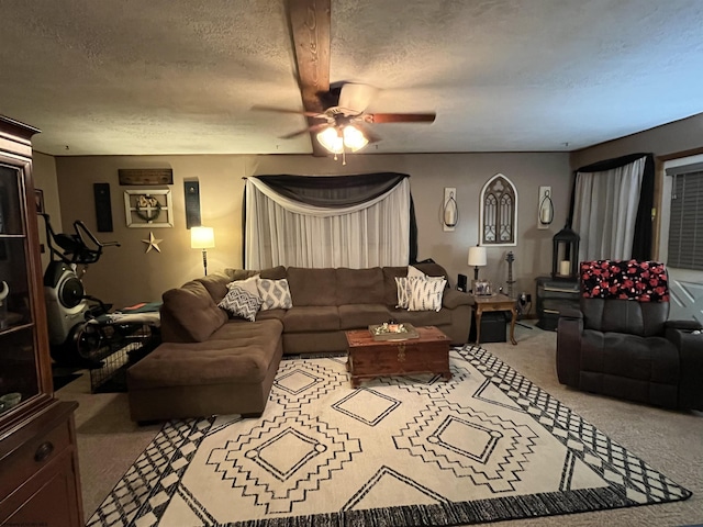 carpeted living area with ceiling fan and a textured ceiling