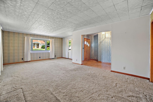unfurnished living room with carpet floors and baseboards