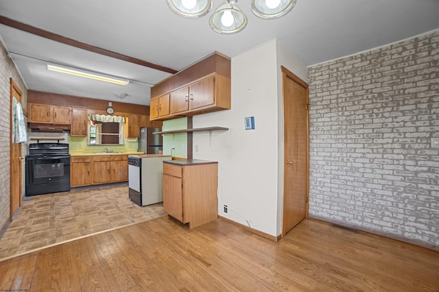 kitchen featuring brick wall, black electric range, a sink, and light wood-style flooring