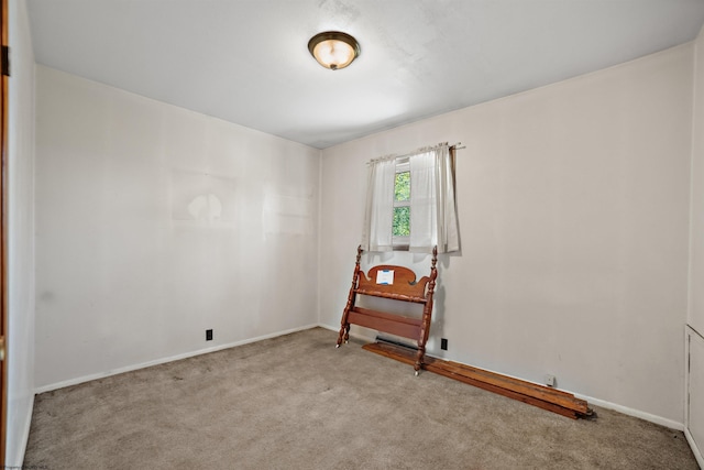 spare room with baseboards and carpet
