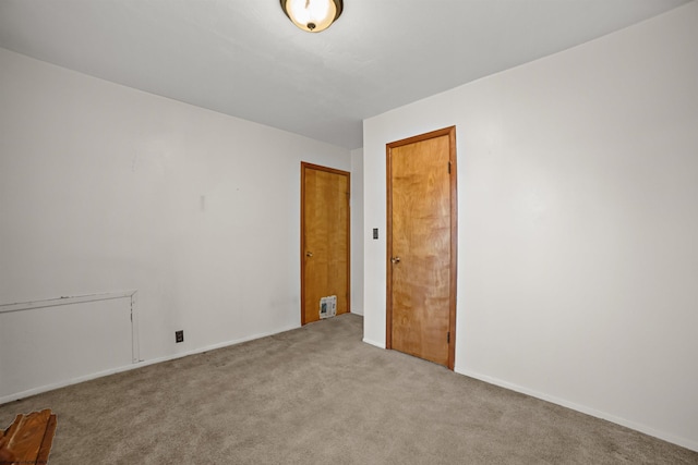 empty room with baseboards and carpet