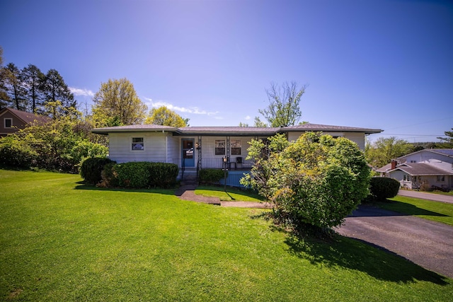 ranch-style home featuring a front lawn and covered porch