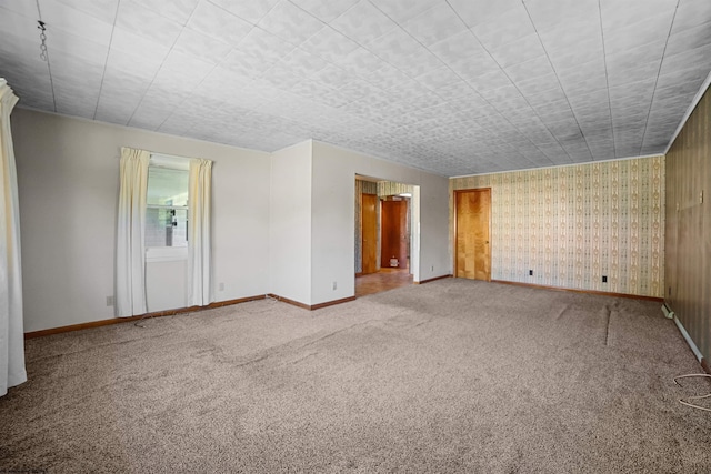 unfurnished room featuring baseboards and carpet